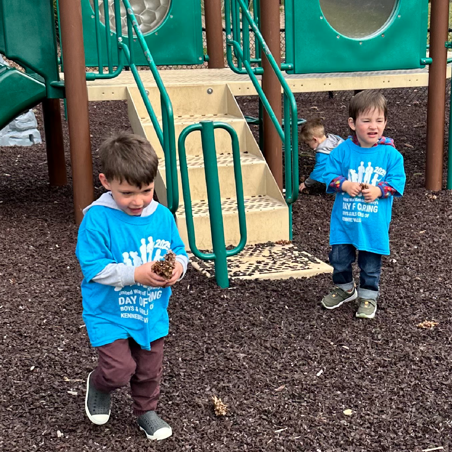 two young boys cleaning up a playground